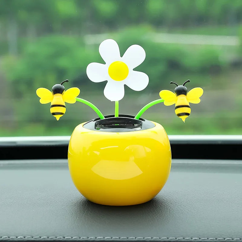 Yellow car dashboard decor with a flower and bees on a blurred green background