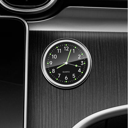 Car dashboard clock with black face and silver frame on a car interior background