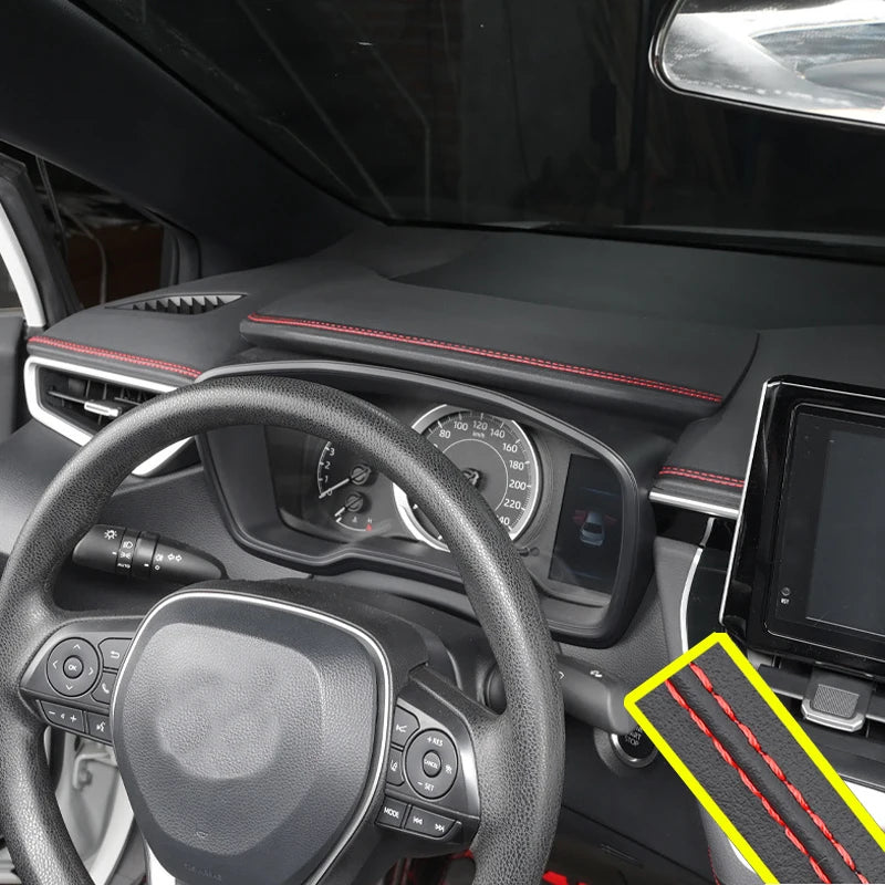Car interior with dashboard and steering wheel, featuring a carbon fiber patterned mat.