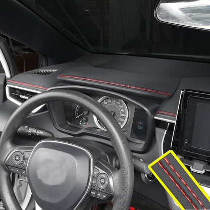 Car interior with dashboard and steering wheel, featuring a carbon fiber patterned mat.