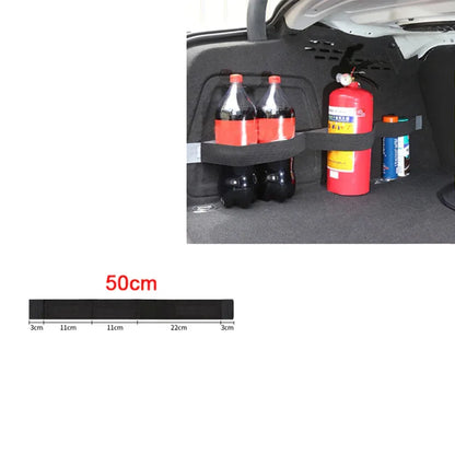 Car trunk organizer with bottles and a fire extinguisher, showing measurement scale.