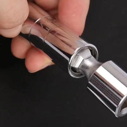 Close-up of a hand holding a metallic tool with a clear cylindrical component against a black background