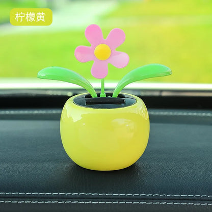 Decorative flower pot with a pink flower on a vehicle  dashboard 