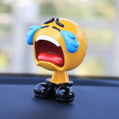 Emoticon figurine with a surprised expression on a car dashboard