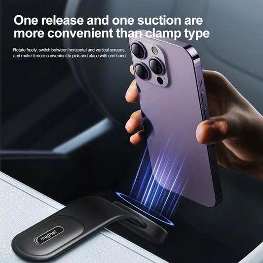 Hand holding a purple smartphone with a magnetic phone holder on a car dashboard.