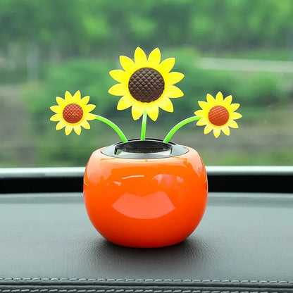 Orange car air freshener with sunflower design on a car dashboard