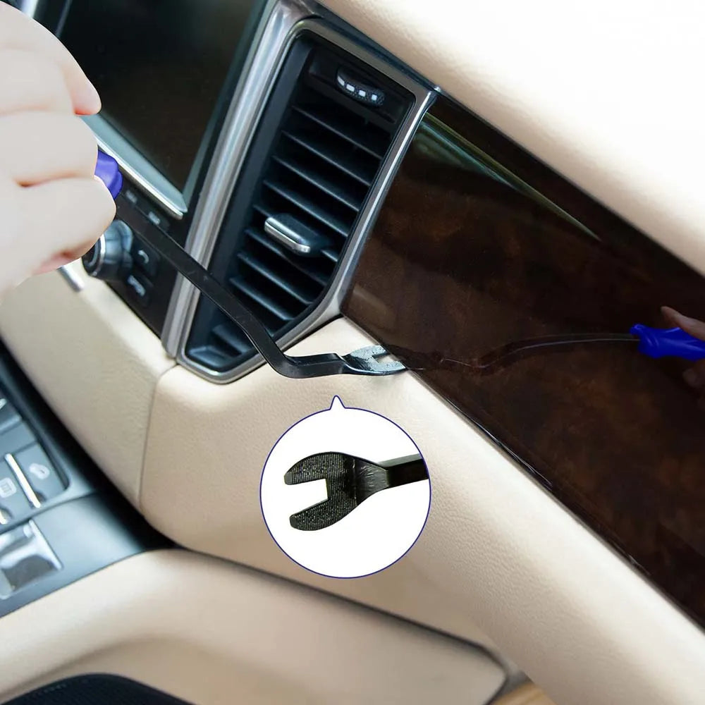 Person using a tool to remove a car trim from a car's dashboard.