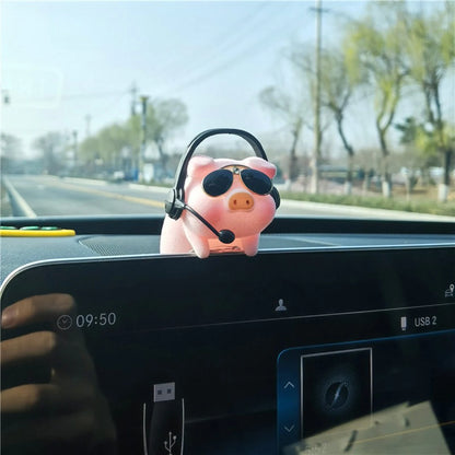 Pink piggy bank with sunglasses and a headset on a car dashboard