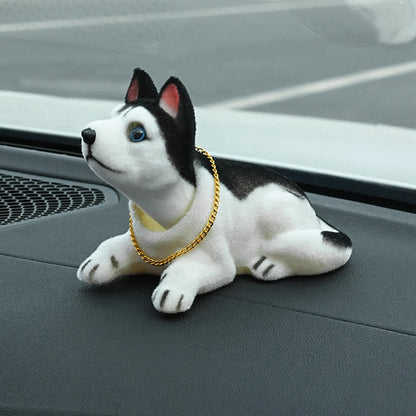 Plush dog toy with a gold chain on a car dashboard