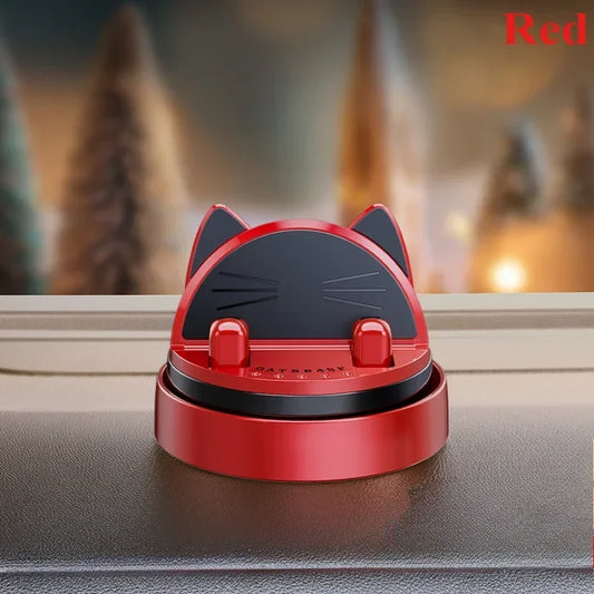 Red and black cat-shaped device on a surface with a blurred background