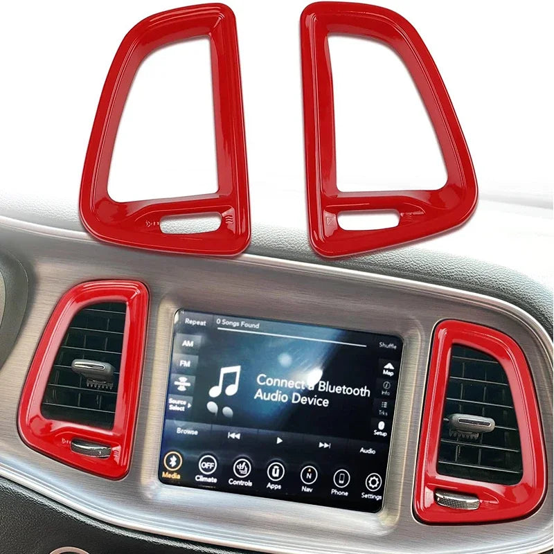 Red car interior trim pieces on a vehicle dashboard with a media display.