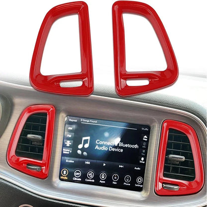 Red car interior trim pieces on a vehicle dashboard with a media display.