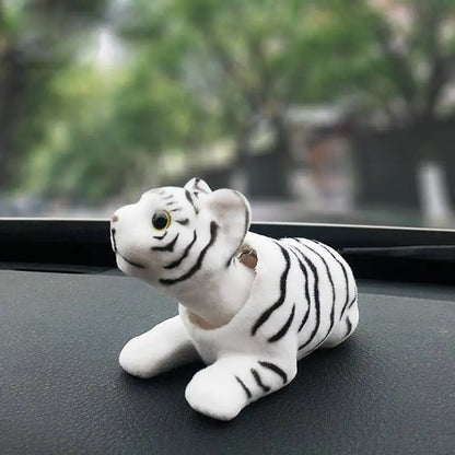 White tiger figurine on a car dashboard with a blurred outdoor background
